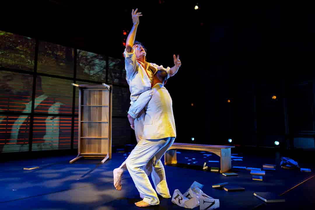 Two men dance in a performance hall