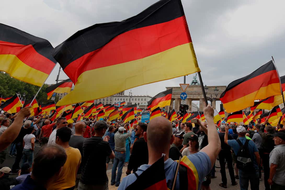 Alternative for Germany (AfD)'s demonstrators wave German flags in front of the Brandenburg Gate (Brandenburger Tor) in Berlin during the 