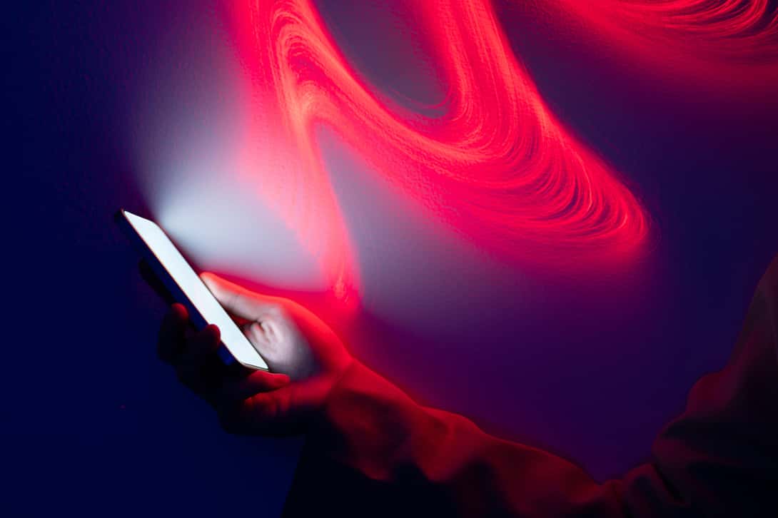 red swirl around a hand holding a phone