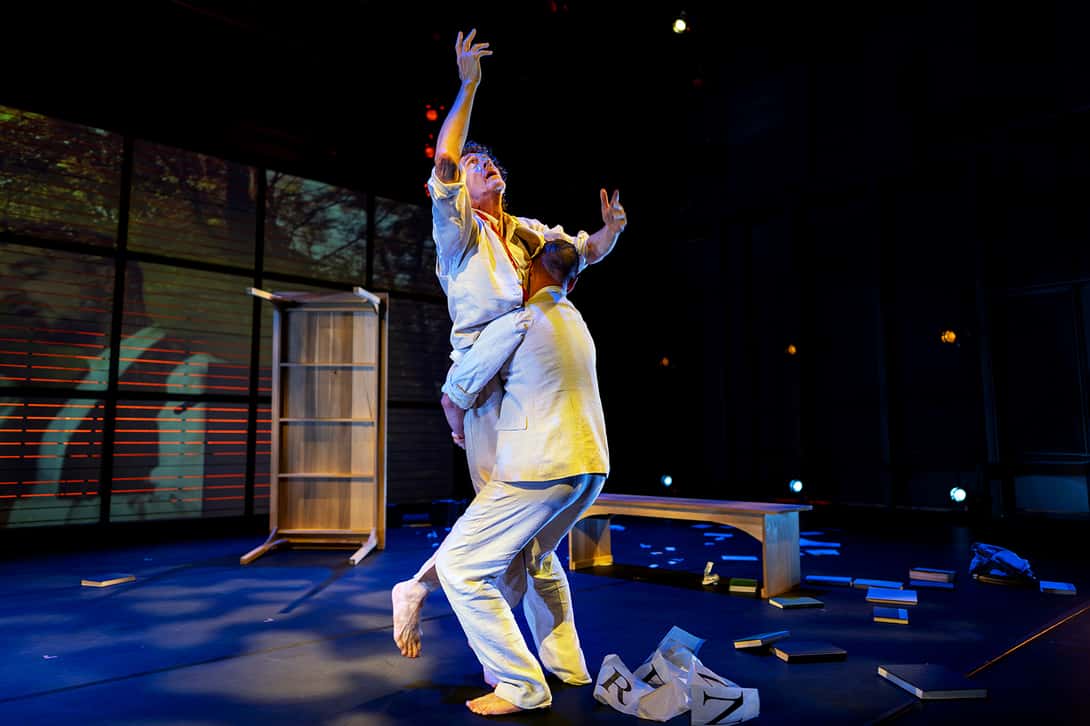 Two men dance in a performance hall