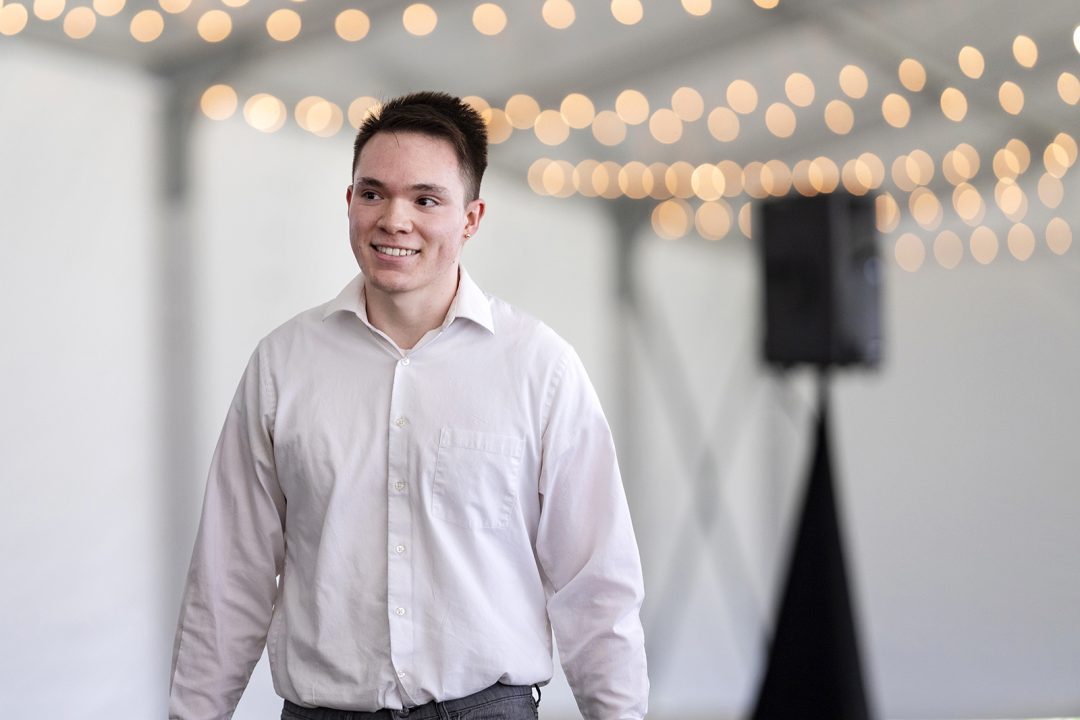 Male student walks toward stage to receive award.
