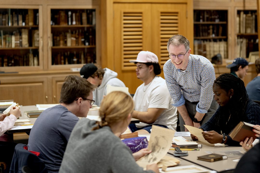 Arnout van der Meer, an associate professor of history, smiles while helping students at Miller Library.