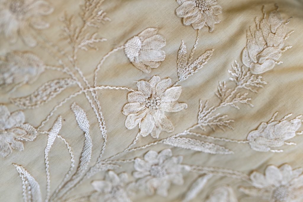 A photo shows delicate embroidery. 