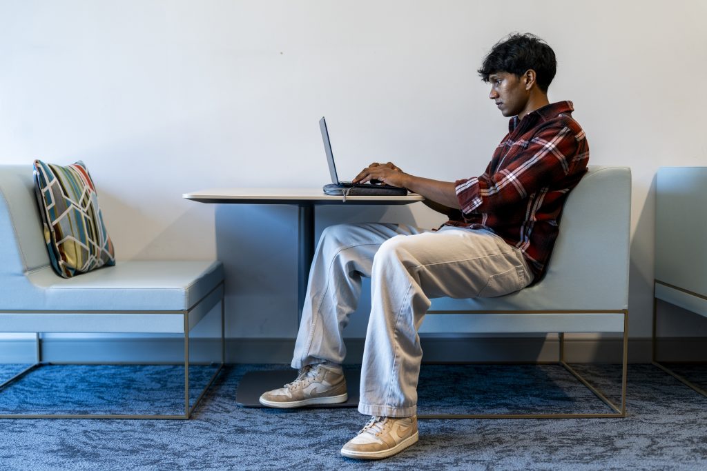 A student works at a laptop computer.