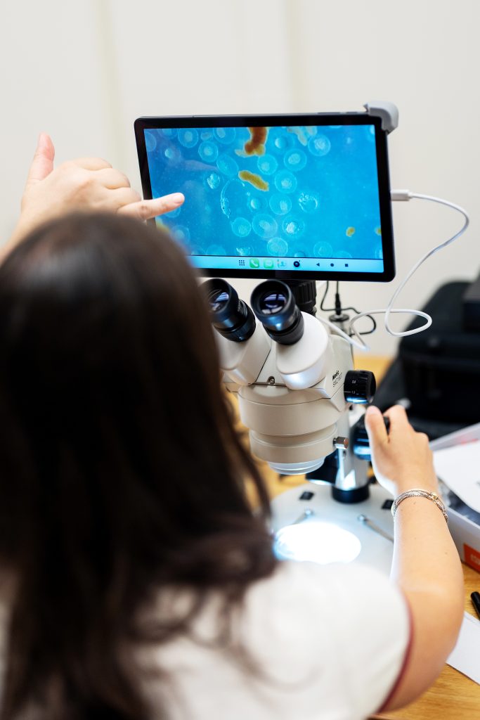 A student operates an electronic microscope.