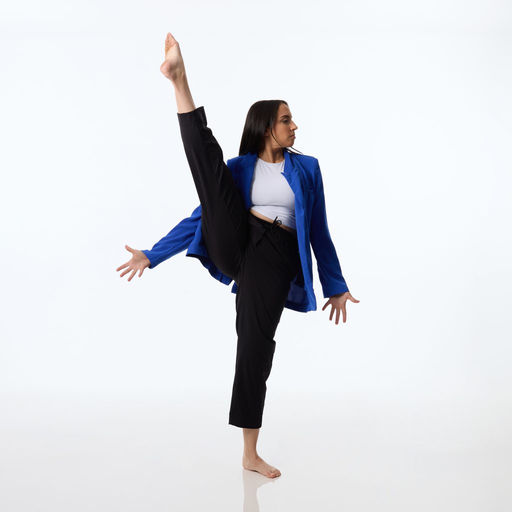 A woman raises one leg in the air.
