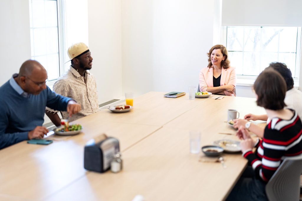 People sit and talk around a table.