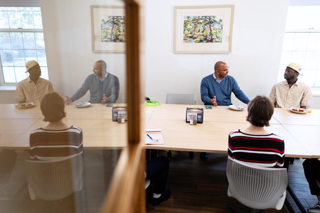 People talk while sitting at a table.