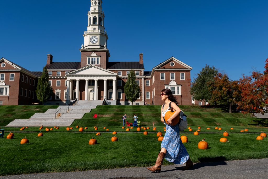 A student walks past the Miller Lawn which is decorated with pumpkins.