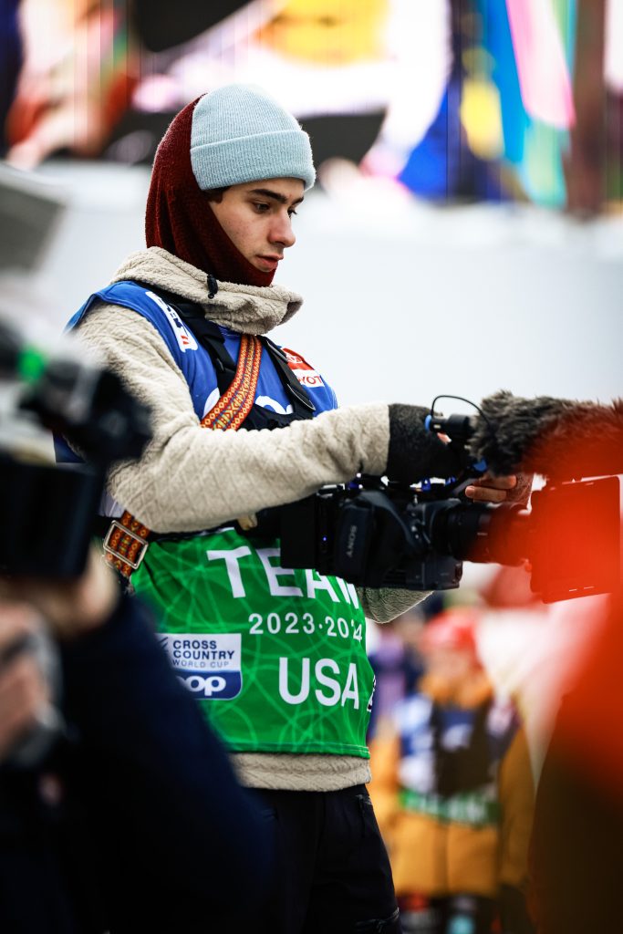 Torsten Brinkema '22, bundled in warm clothing, holds up a video camera while making a documentary about Olympic champion Jessie Diggins. 