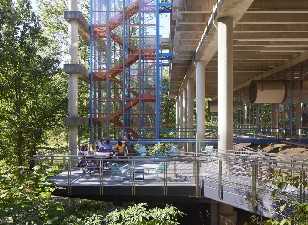 An outdoor patio of a large building with glass windows.