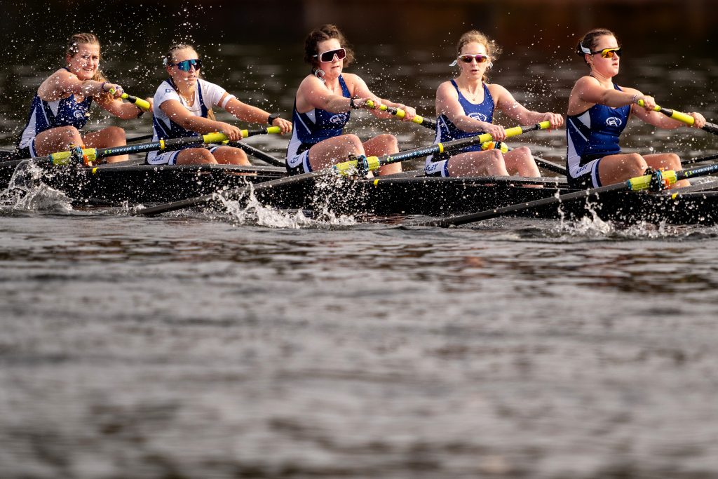 A group of Women's rowers rowing on the water.
