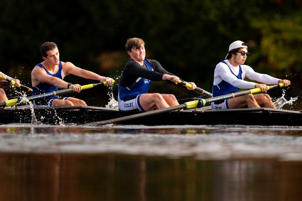 A group of Men's rowers rowing on the water.
