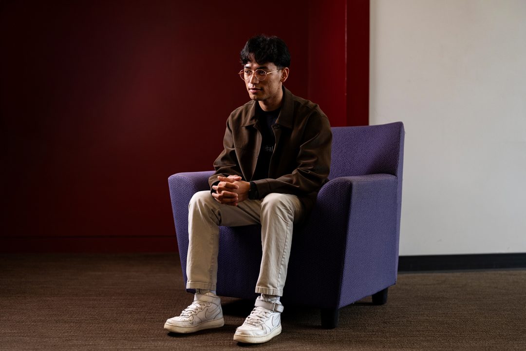Portrait of a male college student sitting in a chair