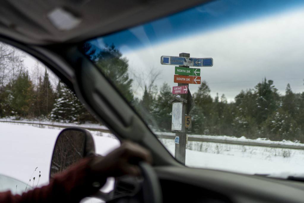 A view of a trail sign looking from within the cab window of a truck.