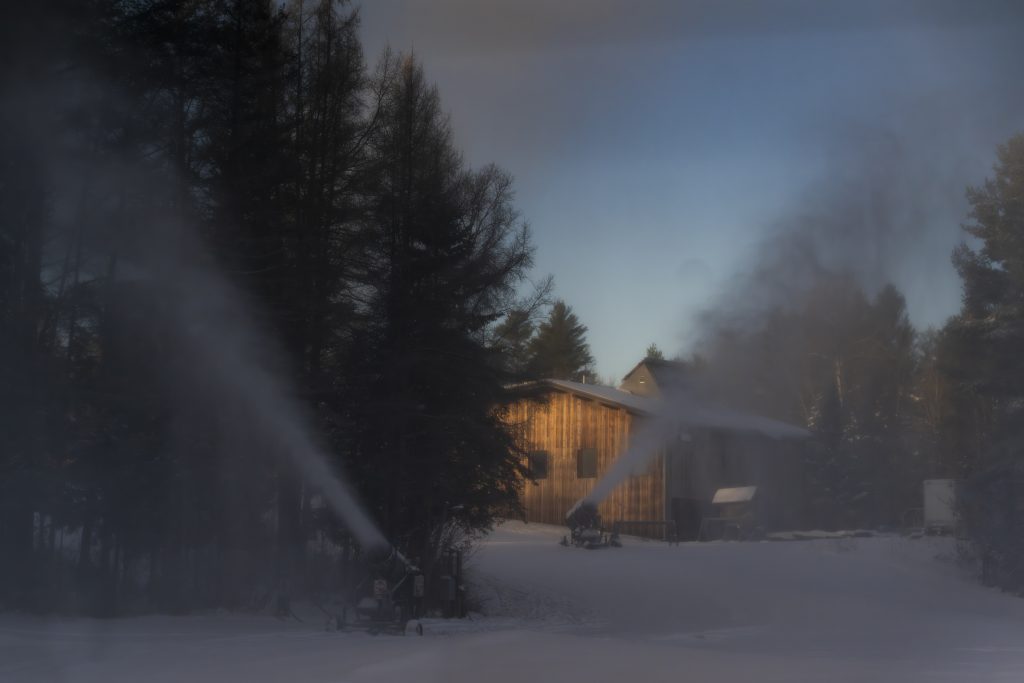 Two snow guns blow snow in opposite directions.