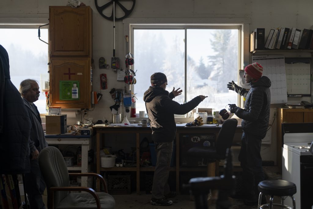 Two people standing by a window having a conversation.