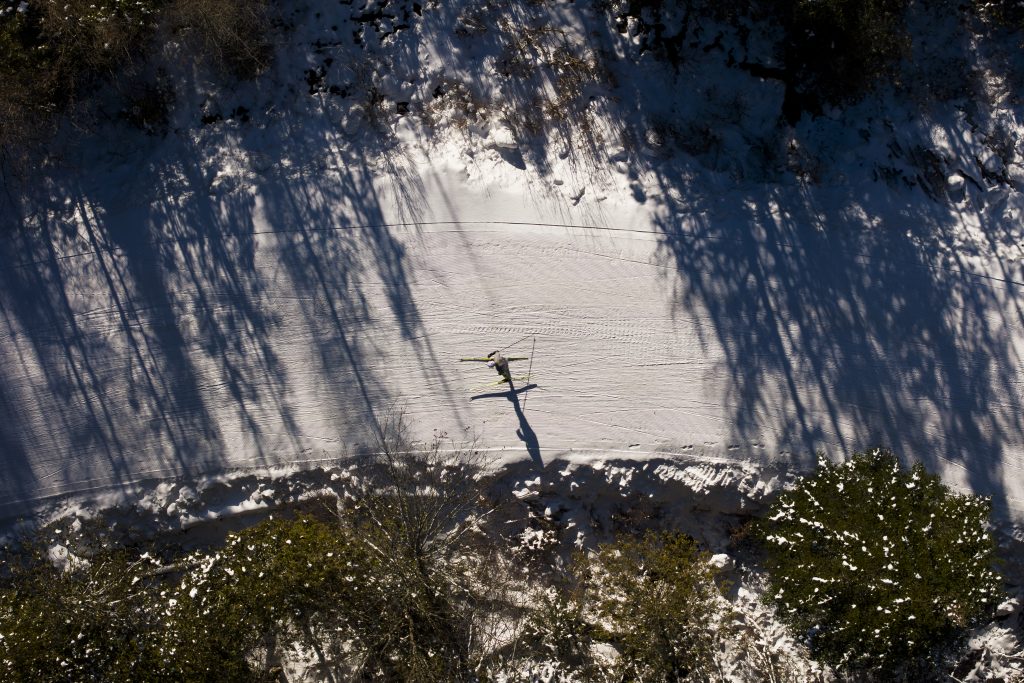 Top-down view of a skier on a groomed trail.