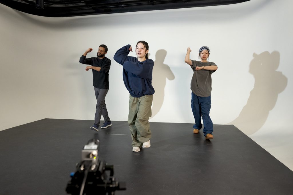 Three dancers performing in a studio.
