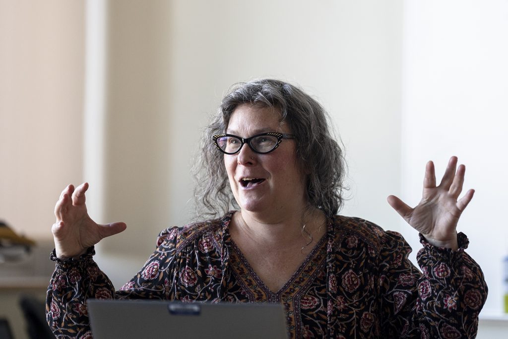 A woman raises her hands as she converses.