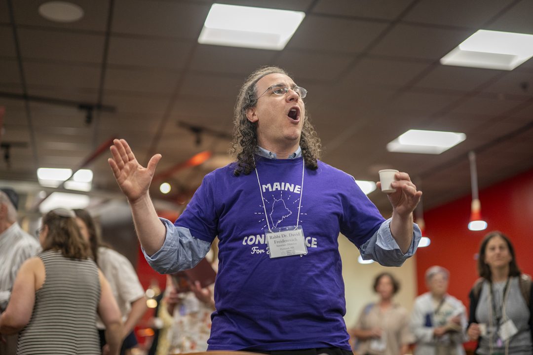 Rabbi leading Shabbat blessing before a dinner