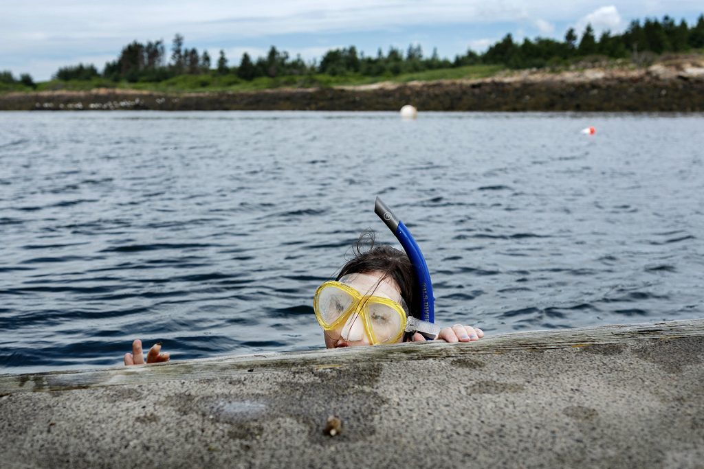 A snorkeler peaks their head above the water.