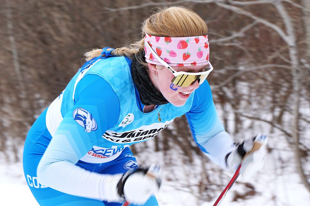 A cross-country skier wearing a Colby uniform competes in a race. 