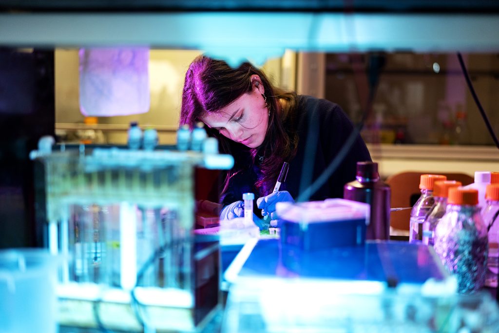 A person using lab equipment looks down.