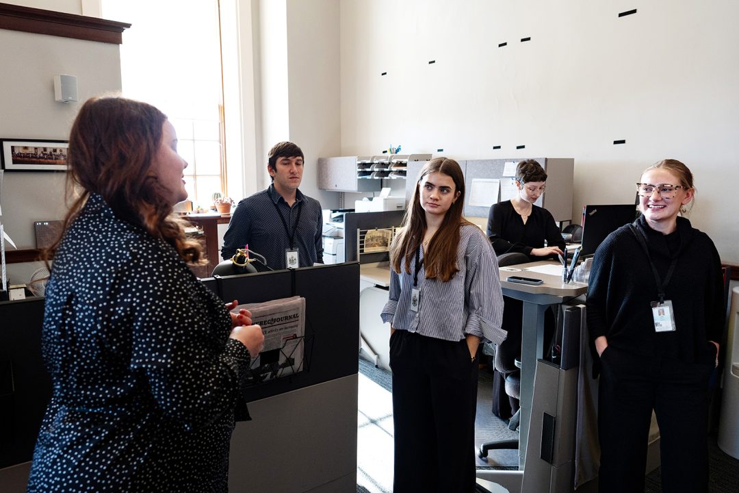 People talk together in an office setting.
