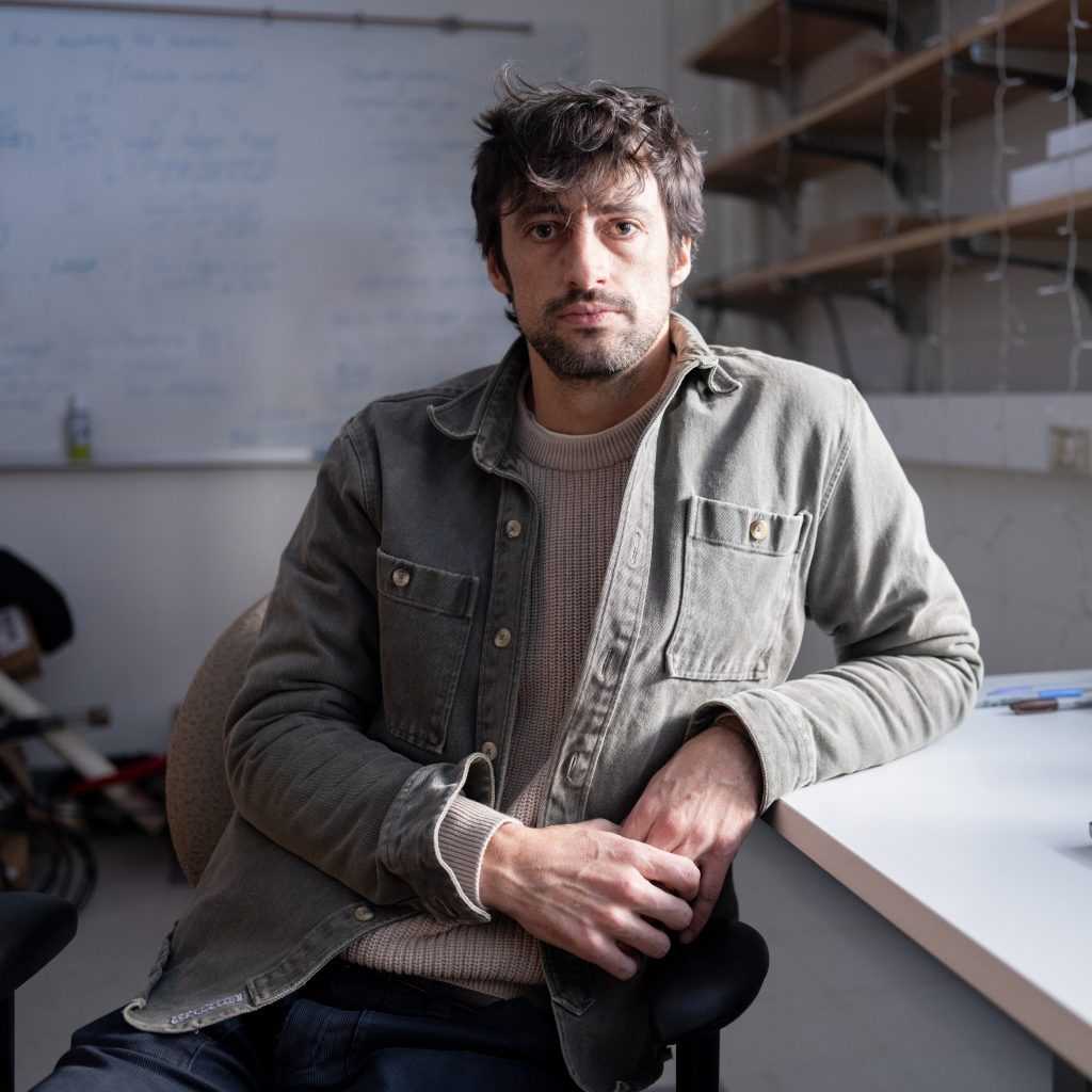 Photo of Evan Dethier sitting at a desk