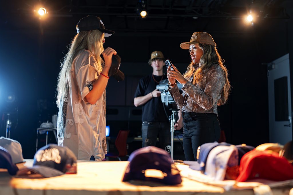 Three students working under bright lights. 