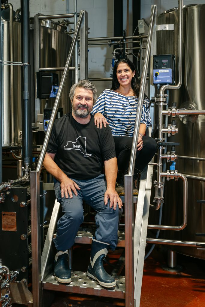Two people pose in a brewery.