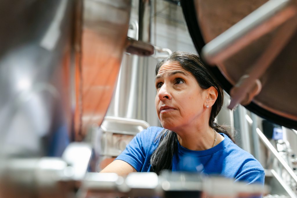 A woman uses brewing equipment.