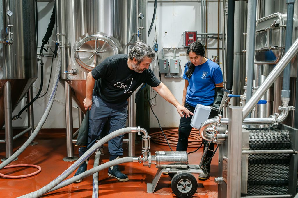 Two people work in a brewery.
