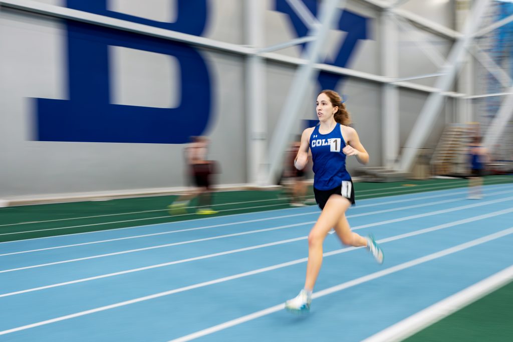 A runner in the inside lane on an indoor track.