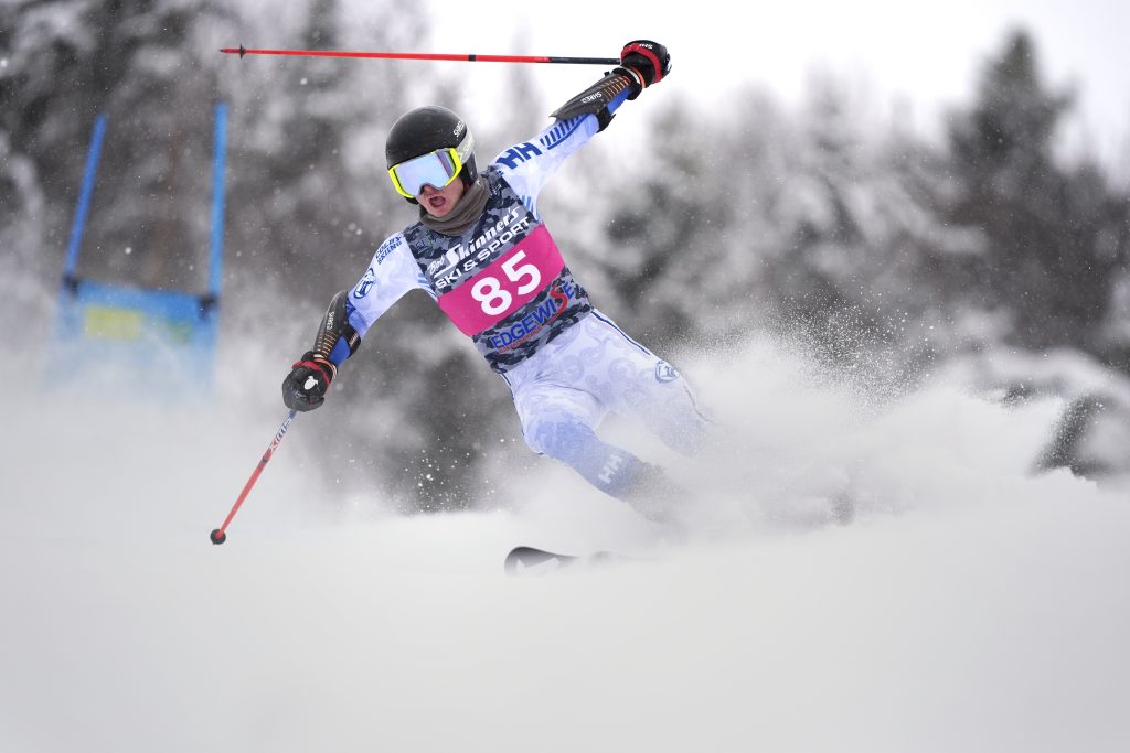 Skier going downhill with poles raised in the air.