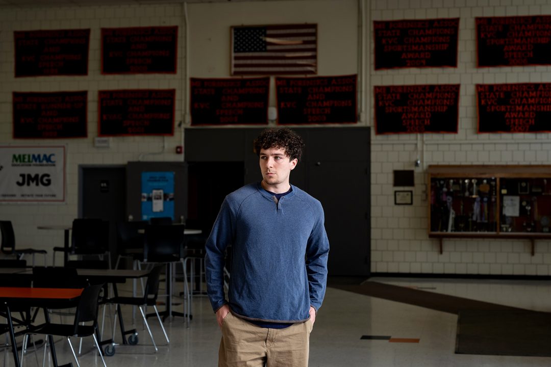 Male college student in the lobby of his high school