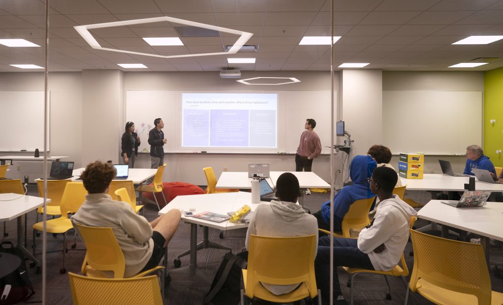 Students look at a presentation on a screen.