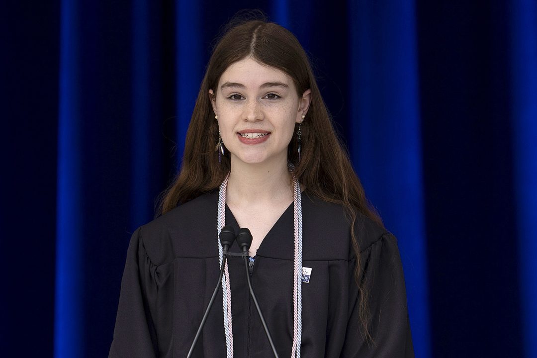 Female college graduate speaking during graduation ceremony