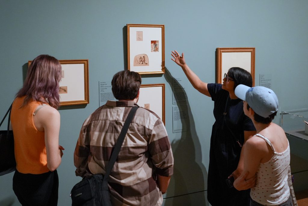People at an art museum talk about art.