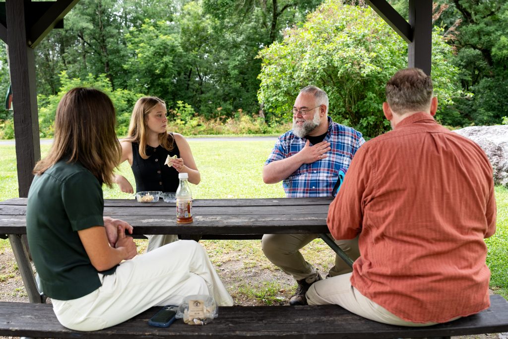 Four people sit around a picnic table