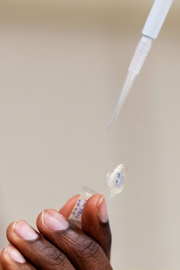 A person's hands do something scientific.