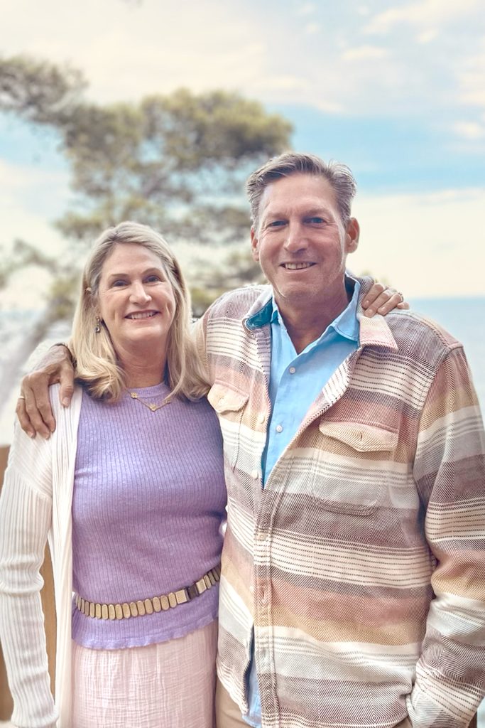 A white couple, husband and wife, posing outdoors for a portrait