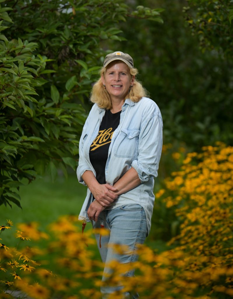A woman stands in a garden