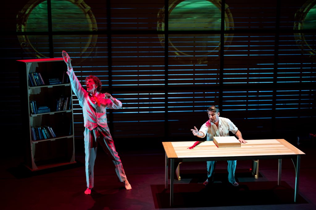 Two men perform on a stage. 