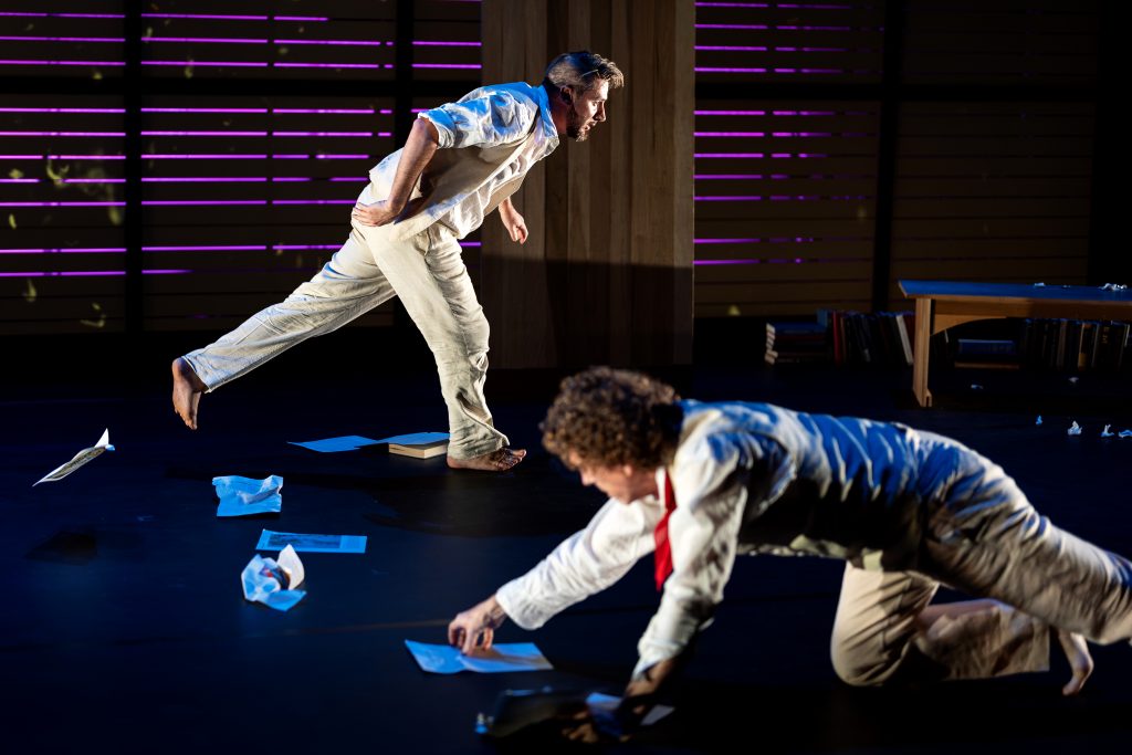 Two men dance on a stage. 