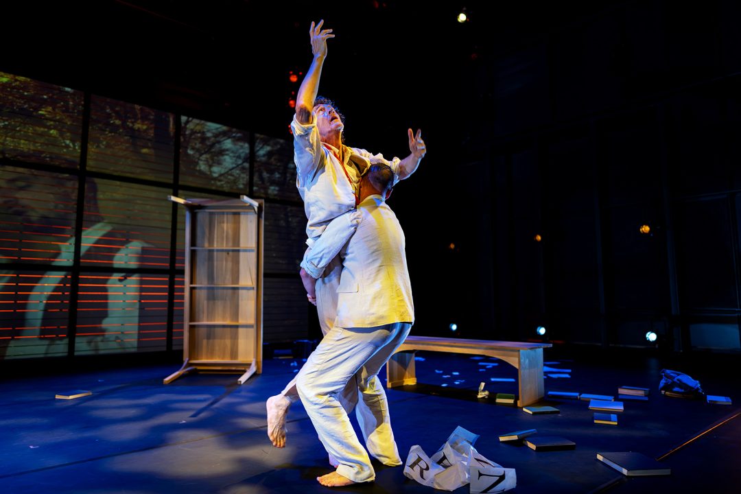 Two men dance in a performance hall
