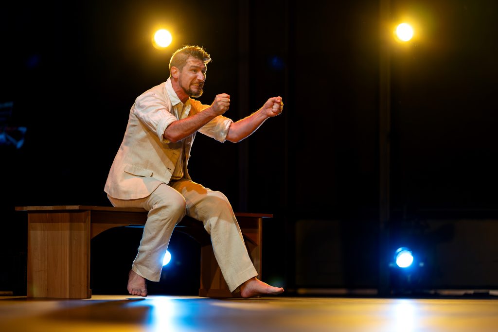 One man gesticulates on a stage. 