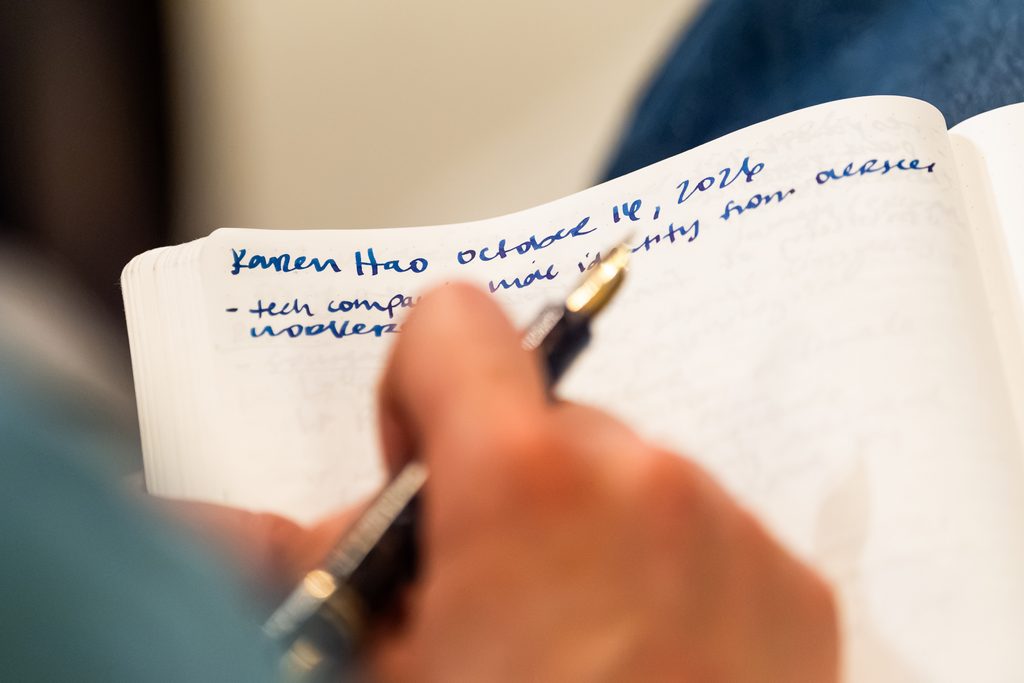 A person takes notes in a notebook. 